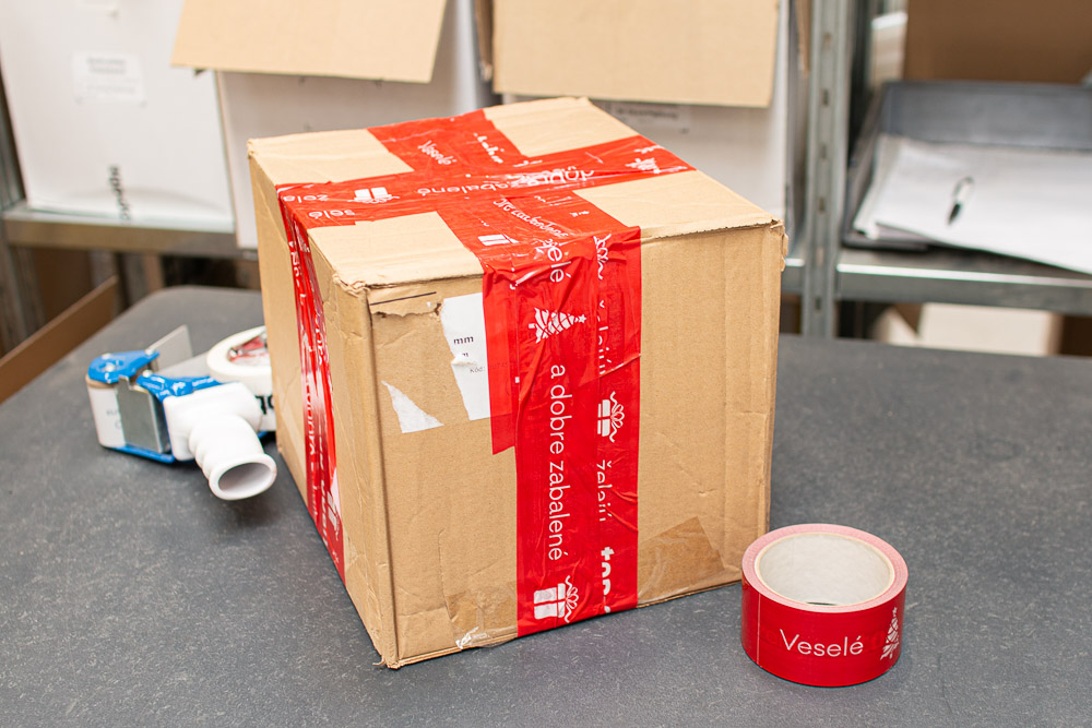Krabice s velkým množstvím lepicí pásky, overpackaging v praxi